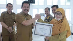 Wakil Wali Kota, Asrul berikan penghargaan OPD terbaik di Pemerintah Kota Padang Panjang kepada Kepala Dinas Kependudukan dan Pencatatan Sipil, Maini