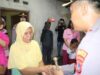 Kapolres Kota Pariaman, Abd. Aziz bersalaman dengan isteri Zamri sebagai penerima bantuan
