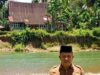 Walinagari Musrial berpose di depan Rumah Gadang Pesisir di Kampung Lubuk Begalung, Kenagarian Aur Begalung, Kecamatan Bayang, Kabupaten Pesisir Selatan