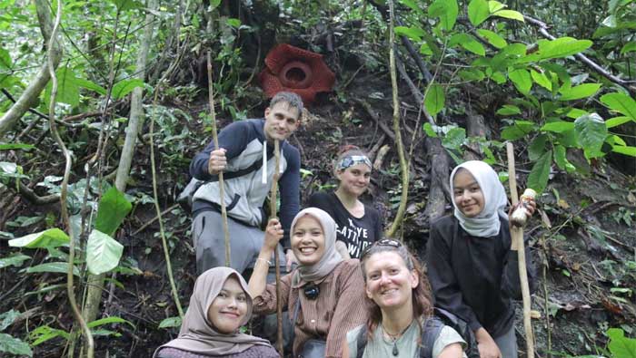 Turis asing bersama local guide foto bersama di lokasi mekarnya Raflesia Arnoldi di Batang Palupuh
