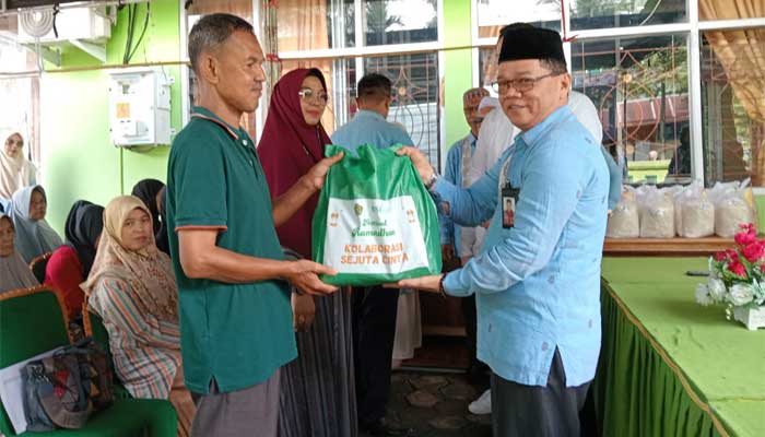 Kepala Kantor Kementerian Agama (Kemenag) Kota Sawahlunto, Dedi Wandra serahkan paket sembako kepada masyarakat penerima manfaat