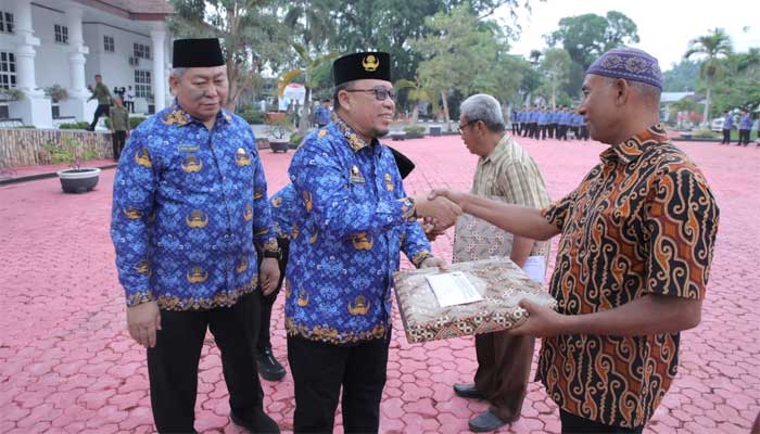 Plh Sekretaris Daerah Kabupaten Asahan, Zainal Aripin Sinaga didampingi Ketua DPK KORPRI, John Hardi Nasution serahkan penali kasih PNS yang pensiun tahun 2024. (f/pemkab)