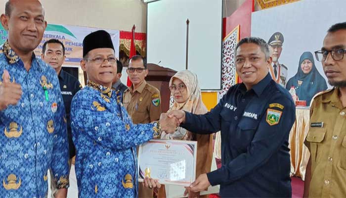 Kepala Disdukcapil Kota Padang Panjang, Rudy Suarman terima penghargaan terbaik 1 Kota Kepemilikan KIA Tertinggi dari Kadis Dukcapil Sumbar, Besri Rahmad, di Balairung Istana Bung Hatta Kota Bukittinggi