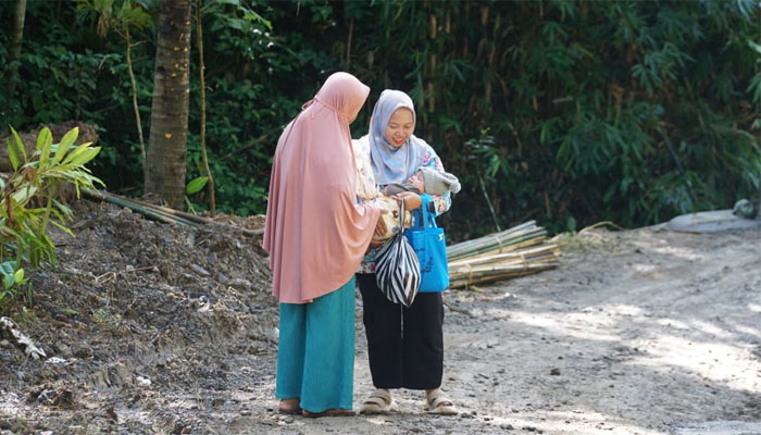Siti melakukan perjalanan untuk imunisasi Balita melewati jalan baru TMMD ke-128