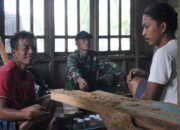 Agus duduk bersama warga lain dan Satgas TMMD Reguler ke-128 Kodim 0702/Purbalingga dengan dinding rumah baru