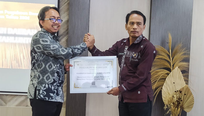 Kepala KPPN Sijunjung, Anton Widodo serahkan piagam penghargaan kepada Kepala Dinas Sosial Pemberdayaan Masyarakat Desa Perempuan dan Perlindungan Anak Kota Sawahlunto, Adriyusman, ata pencapaian penyaluran Dana Desa tercepat pertama tahun 2026