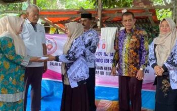 Ketua PGRI Kabupaten Limapuluh Kota, Hj Indrawati serahkan bantuan kepada Elfira yang rumahnya mengalami kebakaran